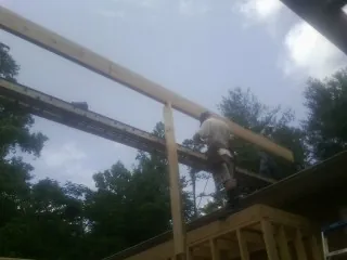 Carpenter setting a ridge beam over a new addition frame — Ice Dam Removal by Roofing Brothers in Hostetter