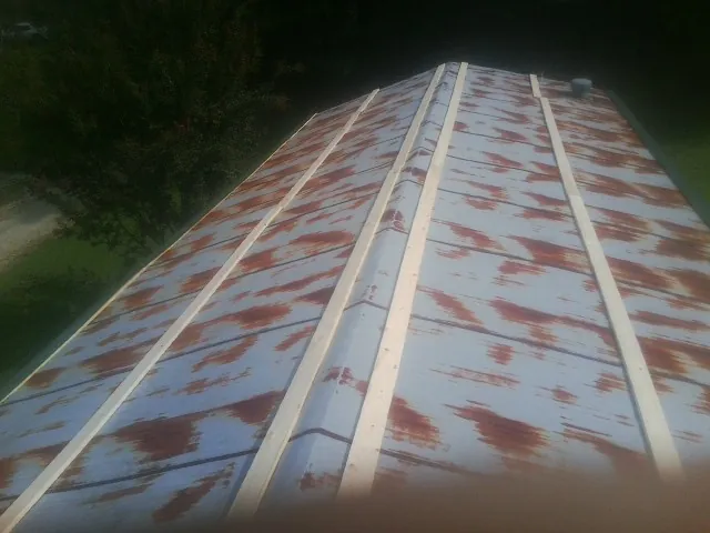 Rusted metal roof panels with new wood purlins before replacement — Storm Damage Roof Repair in Hostetter by Roofing Brothers