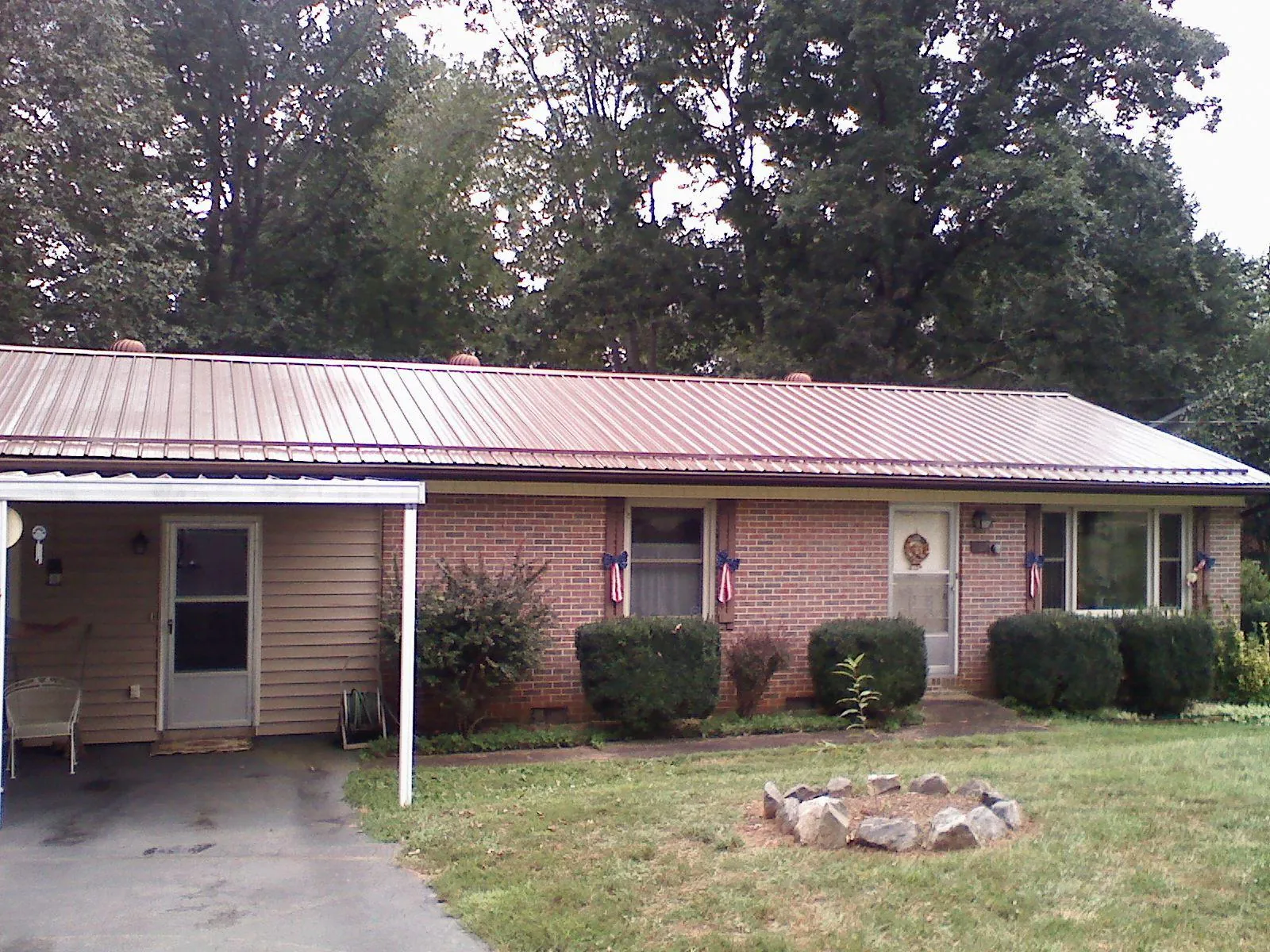 Bronze metal roof and carport on a brick ranch home — Roof Repair work by our crew in Hostetter